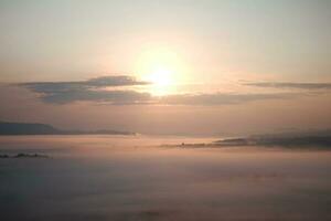 Beautiful Sunset and sunrise on sky and golden twilight time with mist and fog in valley of layer mountain photo
