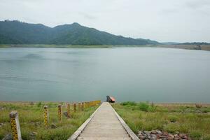 Long stairs at the pier for transportation with tradition boat on water and river in dam, Thailand photo