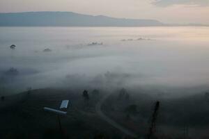 Beautiful Sunset and sunrise on sky and golden twilight time with mist and fog in valley of layer mountain photo