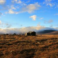 An old house against the background of a misty mountain on the Wrangel Peninsula photo