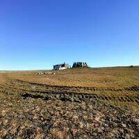 An old wooden structure on the Arctic tundra background photo