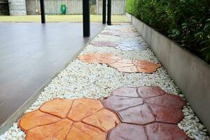 Walk way made frome cobblestone beside brown floor, flowers shape cobblestone colorful way, Thailand. photo