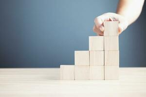 hand of a businessman stacking wood empty ten blocks with copy space for text or symbols, development concept for growth success process. photo