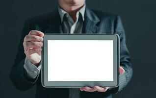 businessman in suit stand showing a tablet white screen display for mockup content. photo