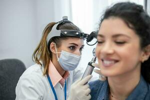 Hearing exam for a woman. Diagnosis of impairment and hearing testing in adults. Patient woman during an ear check-up with an audiologist photo