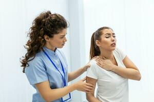 mujer médico osteópata en médico uniforme fijación mujer pacientes hombro y espalda articulaciones en manual terapia clínica durante visita. profesional osteópata durante trabajo con paciente concepto foto