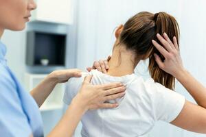 mujer médico osteópata en médico uniforme fijación mujer pacientes hombro y espalda articulaciones en manual terapia clínica durante visita. profesional osteópata durante trabajo con paciente concepto foto