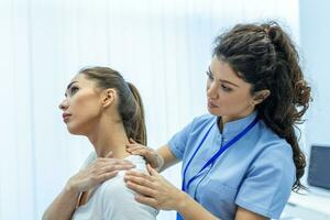 mujer médico osteópata en médico uniforme fijación mujer pacientes hombro y espalda articulaciones en manual terapia clínica durante visita. profesional osteópata durante trabajo con paciente concepto foto