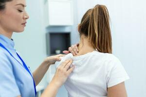 mujer médico osteópata en médico uniforme fijación mujer pacientes hombro y espalda articulaciones en manual terapia clínica durante visita. profesional osteópata durante trabajo con paciente concepto foto