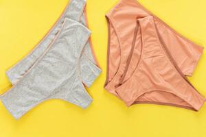 Set of colorful underpants on yellow background, close up photo