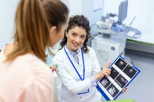 Gynecologist showing a picture with ultrasound to a young woman patient, explaining the features of women's health during a medical consultation in the office photo