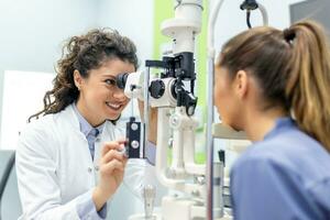 ojo médico con hembra paciente durante un examen en moderno clínica. oftalmólogo es utilizando especial médico equipo para ojo salud ahorro y mejorando. foto