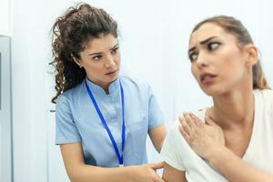 mujer médico osteópata en médico uniforme fijación mujer pacientes hombro y espalda articulaciones en manual terapia clínica durante visita. profesional osteópata durante trabajo con paciente concepto foto