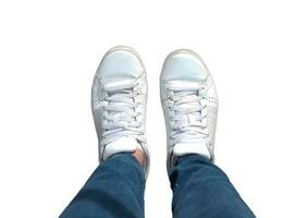 Top view of white sneakers and Blue jeans on woman legs isolated on white background photo