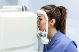 médico pruebas para ojos con especial óptico aparato en moderno clínica. oftalmólogo examinando ojos de un paciente utilizando digital microscopio durante un médico examen en el oftalmológico oficina foto