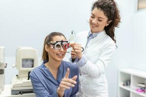 Optometrists changes lenses in trial frame to examine the vision of young woman patient vision at ophthalmology clinic, selective focus photo