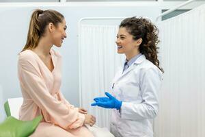 Gynecologist talking with young female patient during medical consultation in modern clinic. Patient with a gynecologist during the consultation in the gynecological office photo