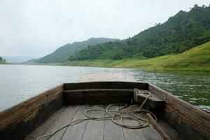 Beautiful landscape of  river with tropical rain forest and wild jungle and tradition wooden long tail boat in dam, Thailand photo