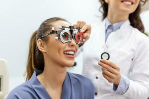 oftalmólogo que examina a la mujer con marco de prueba de optometrista. paciente femenina para comprobar la visión en la clínica oftalmológica foto