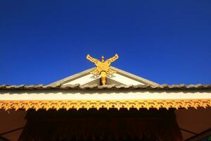 Receiver antenna is tied with wooden sculpture decorated on the roof of Temple lanna style in northern of Thailand photo