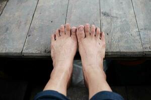 Dirty and wet woman Barefoot on wooden boat. photo