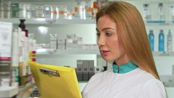 Cheerful female chemist smiling to the camera, while working at drugstore video