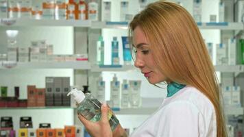 Female pharmacist smiling to the camera, holding two medication bottles video