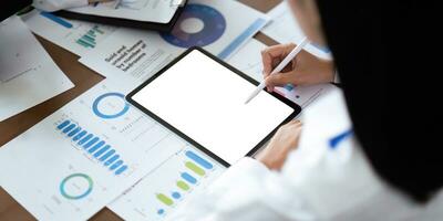 Blank screen mockup of man hand working on tablet work while sitting at the table, mockup blank screen for graph finance display or graphic design workspace photo
