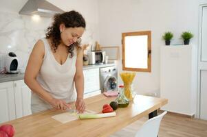 Waist up portrait of smiling black woman cooking healthy meal in kitchen and cutting vegetables, copy space photo