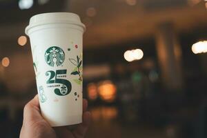 bangkok, Tailandia - octubre 18, 2023 hombre participación reutilizable taza, 25 aniversario, Starbucks tailandia, obtener 1 gratis. edición limitada foto