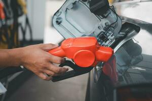 Male gas station attendant refueled car with petrol, refueling car at the refuel station. Concept travel and transportation. photo