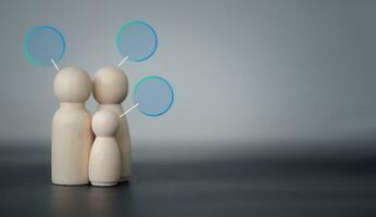 Wood peg doll family with empty circle speech bubble, sending a message. photo