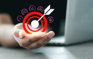 Man hand holding icons target board for successful marketing set up business objective target. photo