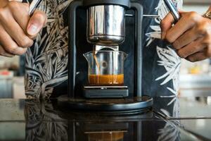 Barista making hot espresso shot from flair espresso coffee maker at coffee cafe. photo