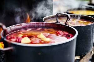 Beverages fruits and berries hot mulled wine in pots with steam in street food market. Generative AI photo