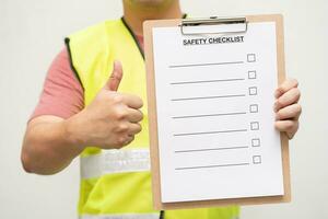 Profession technician engineer thump up with blank safety checklist. Safety audit and risk verification. Conceptual caption Safety Checklist. photo