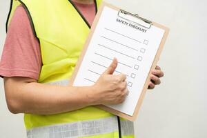 Profession technician engineer thump up with blank safety checklist. Safety audit and risk verification. Conceptual caption Safety Checklist. photo