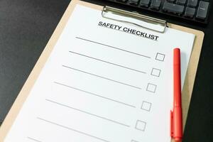 Blank checklist paper during safety audit and risk verification. safety checklist form with red pen on the desk. copy space for text. photo