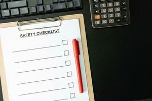 Blank checklist paper during safety audit and risk verification. safety checklist form with red pen on the desk. copy space for text. photo