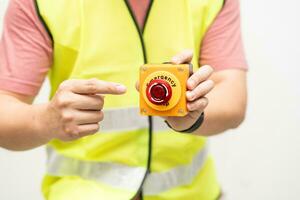 Engineer pressing an emergency stop button with copy space. Industrial working operating process. Stop Switch machine malfunctioning for safety. photo