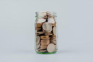 Saving coins in a glass jar money saving concept Finance and banking, mutual funds, cash, cash flow, income, wages, investments, financial growth and investment. photo