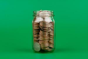 Saving coins in a glass jar money saving concept Finance and banking, mutual funds, cash, cash flow, income, wages, investments, financial growth and investment. photo