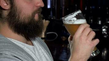 barbudo homem sorridente depois de bebericando delicioso Cerveja às a Barra video