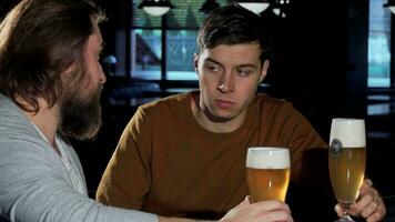 Depressed young man drinking at the bar with his friend video