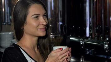 Beautiful young woman smiling, looking away dreamily, enjoying her coffee video