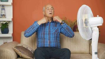 el hombre utilizando el ventilador es abrumado por el calor. video