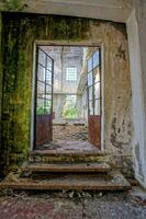 an old abandoned building with a door and stairs photo
