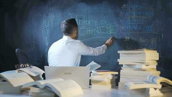 Historian man writing history of china on blackboard. video