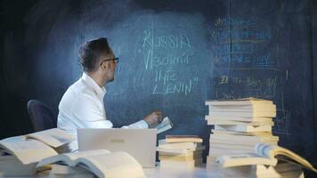 Historian man writing Vladimir Ilyic Lenin on blackboard. video