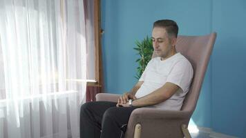 Happy and peaceful man. He is sitting in front of the window. video
